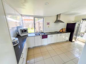 a kitchen with a sink and a microwave at Vista Air conditioned Holiday Dream Castle Youth Hotel in Brisbane +65 photos