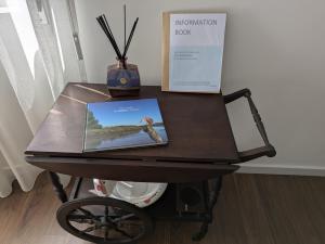 a wooden table with a book on top of it at Apúlia Beach Avenue in Apúlia