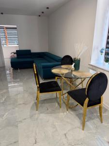 a living room with a couch and a table and chairs at Apartament Ostrowiec Świętokrzyski Browarna 4 in Ostrowiec Świętokrzyski