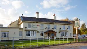 un edificio blanco con un cartel delante en The Golden Pheasant en Knutsford