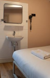 a bathroom with a sink and a mirror on the wall at CS Hotel in Amsterdam