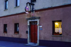 a building with a red door and a sign on it at LAAS ART GALLERY in Stari Trg pri Ložu