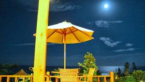 un tavolo e sedie con ombrellone su una spiaggia di Hai Yuansu 178 a Yanliau
