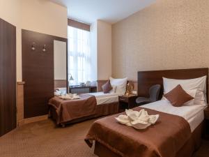 a hotel room with two beds and a chair at Central Hotel 21 in Budapest