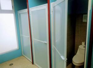 a bathroom with a toilet and a glass shower door at Hostal el búho Morelia in Morelia