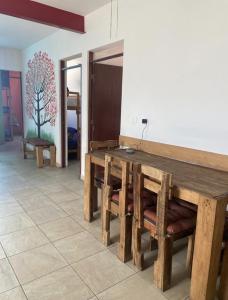 a dining room with a wooden table and benches at Hostal el búho Morelia in Morelia