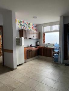 a kitchen with wooden cabinets and a white refrigerator at Hostal el búho Morelia in Morelia