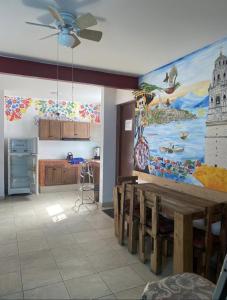 a kitchen with a table and a painting on the wall at Hostal el búho Morelia in Morelia