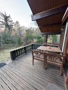a wooden deck with a wooden table and bench at Haus Sommerfeld in Meißendorf