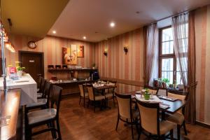 a restaurant with tables and chairs in a room at Central Hotel 21 in Budapest