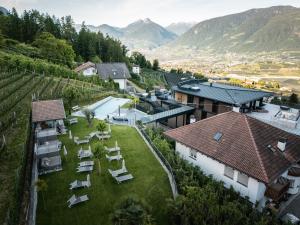 an aerial view of a house with a yard with chairs at Hotel Alpenrose in Schenna