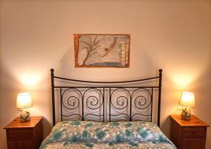 a bedroom with a bed and two night stands with lamps at Villa Etruria Guest House in Pitigliano +28 photos