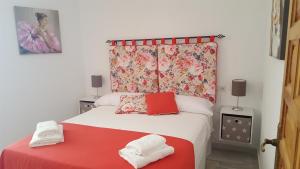 een slaapkamer met een rood en wit bed en 2 handdoeken bij Casa Típica Cordobesa in Córdoba