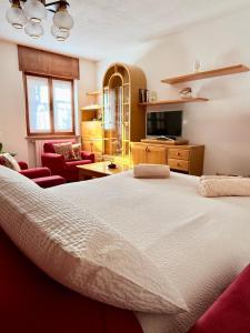 a bedroom with a large bed and a living room at Incentro in Grosio
