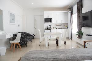 a white room with a table and chairs and a kitchen at Peacehaven on Sea in Wilderness