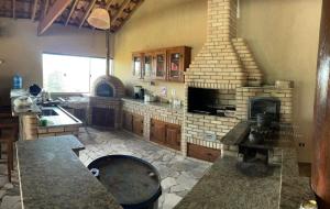 a kitchen with a large stone fireplace in a kitchen at Recanto do Joao Sta Isabel in Santa Isabel