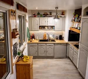a kitchen with white cabinets and bananas on the counter at Le chalet in Oullins