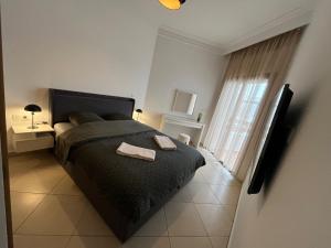 a bedroom with a black bed and a window at Beachfront Apartment in Assilah, Private Solarium, 4 Pools, Secure Residence, WiFi, Parking in Asilah +71 photos