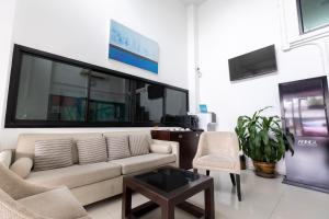 a living room with a couch and chairs and a tv at Annex Lumpini Bangkok in Bangkok +24 photos
