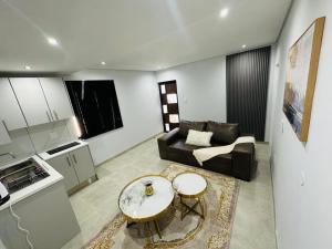 a living room with a couch and a table at DECADE Self-catering in Swakopmund +33 photos