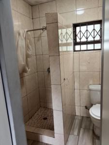 a bathroom with a shower with a toilet at AMASHIYA flats in Richards Bay +1 photo