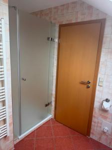 a bathroom with a shower and a wooden door at Ferienzimmer Schürer in Lauter