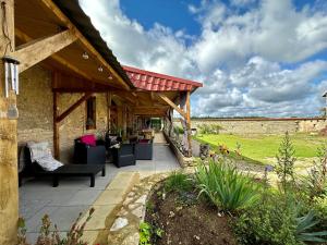 a patio with couches and chairs under a pavilion at La Ferme de Tart in Verdonnet