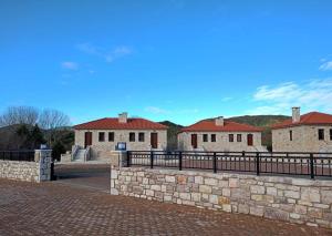 a stone wall in front of some buildings at Philoxenia by nature in Karkaloú