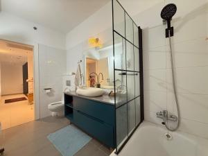 a bathroom with a sink and a glass shower at שלוות העמק - דירת 3 חדרי שינה במיקום מרכזי in Ganne Tiqwa +29 photos