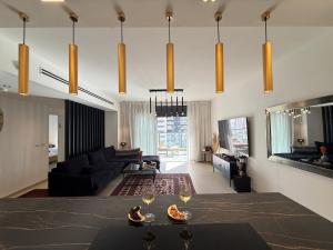 a living room with a couch and a table with wine glasses at שלוות העמק - דירת 3 חדרי שינה במיקום מרכזי in Ganne Tiqwa