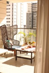 a balcony with two wicker chairs and a coffee table at שלוות העמק - דירת 3 חדרי שינה במיקום מרכזי in Ganne Tiqwa