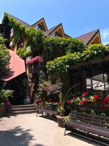 a building with flowers and a bench in front of it at Hotel Sumski Feneri in Trnovo