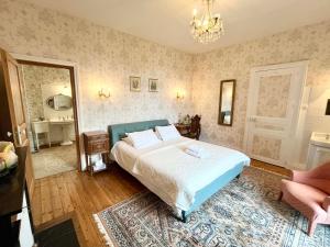 a bedroom with a bed and a chandelier at La Source in Availles-Limouzine