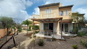 a house with a balcony and a table in front of it at Casa Jazmin in Cala Bona