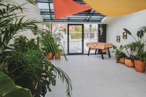 a room with a ping pong table and potted plants at lyf Gambetta Paris in Paris