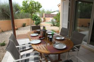 a wooden table and chairs on a patio at Casa Jazmin in Cala Bona