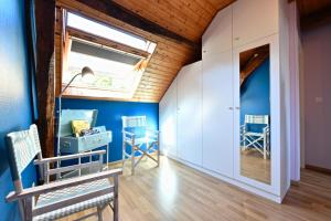 a room with blue walls and a window and chairs at Le mouly/grand gite in Miossens-Lanusse