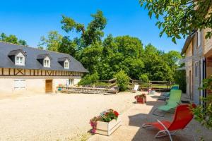 an outdoor patio with chairs and a house at Le mouly/grand gite in Miossens-Lanusse