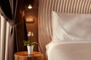 a bedroom with a bed and a table with a vase on it at B&B Il Vicoletto in Santarcangelo di Romagna