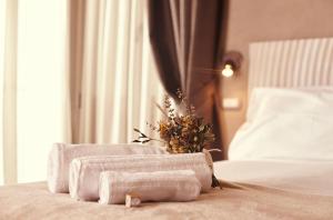 a pile of towels on a bed with a plant at B&B Il Vicoletto in Santarcangelo di Romagna