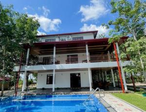 a house with a swimming pool in front of it at Yaalu-Yaalu in Welikanda