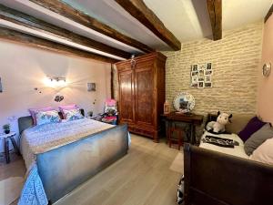 a bedroom with a large bed and a desk at La Ferme de Tart in Verdonnet