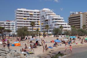 a group of people on a beach with buildings at The Miks Sur Mer 2 in Roses