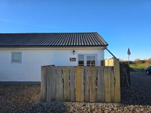 a house with a wooden fence in front of it at Sandra Fewo nähe Rømø in Bredebro in Bredebro