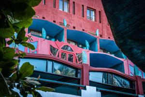 a tall red building with blue and pink at Hotel Sokhamon in Dakar