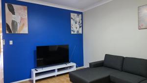 a living room with a couch and a blue wall at The Prospect Executive Home in Prospect