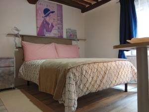 a bedroom with a bed with pink pillows at Casa Giovy in Roccastrada