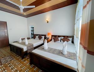 two beds in a room with a room with at Yaalu-Yaalu in Welikanda