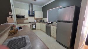 a kitchen with a stainless steel refrigerator and white cabinets at The Prospect Executive Home in Prospect