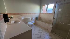 a bathroom with a toilet and a sink and a shower at The Prospect Executive Home in Prospect +8 photos